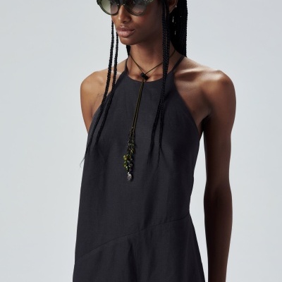 Mulher com vestido preto sem mangas e óculos de sol