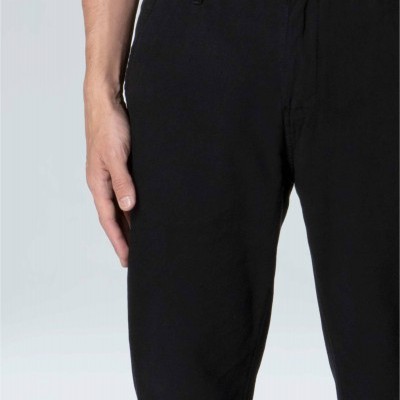 Calças pretas com bolso lateral e botão em fundo claro