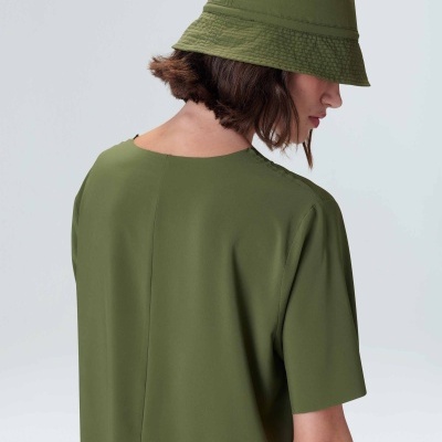 Pessoa com chapéu bucket verde e camisola verde vista de costas