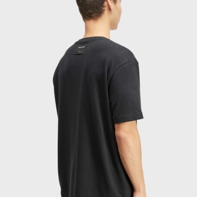 Homem de costas a usar t-shirt preta com etiqueta na parte superior das costas