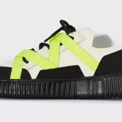 Tênis desportivo branco com sola preta e fitas amarelo-neon cruzadas