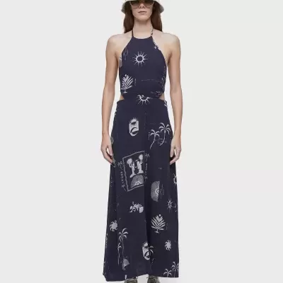 Modelo veste conjunto azul escuro com estampas brancas, chapéu branco e ténis cinzentos