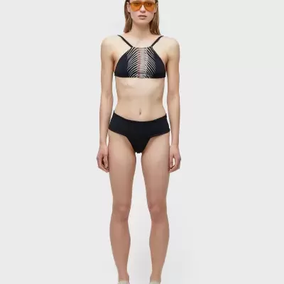 Modelo a usar biquíni preto com padrão branco no top