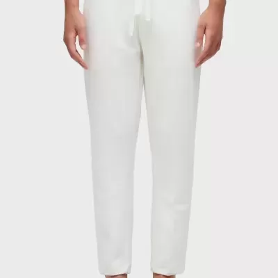 Calças brancas de algodão com cordão à cintura e sandálias pretas