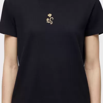 T-shirt preta com bordado dourado de flor no peito