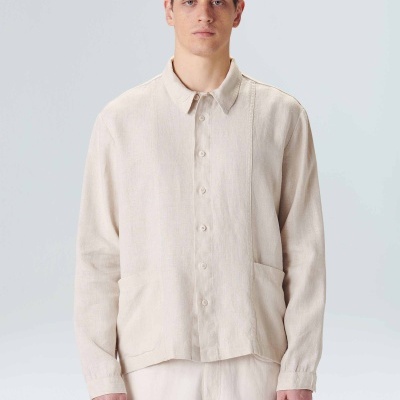 Homem com camisa bege clara de manga comprida e calças bege