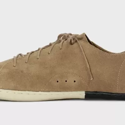 Ténis castanho claro em camurça com atacadores e sola branca com detalhe preto