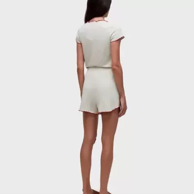 Conjunto de pijama creme com detalhes vermelhos em fundo branco