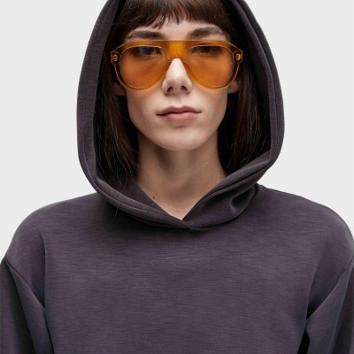 Pessoa com óculos de sol âmbar e sweatshirt capuz castanho escuro