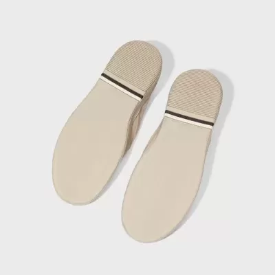 Sapatos bege com sola lisa e detalhes em relevo no calcanhar