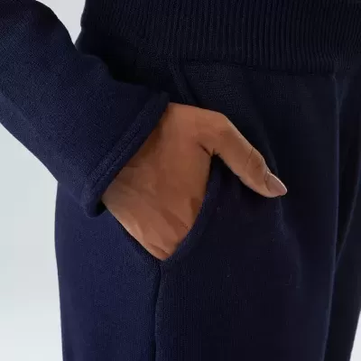 Calças e camisa azul escuro em malha grossa com mão no bolso