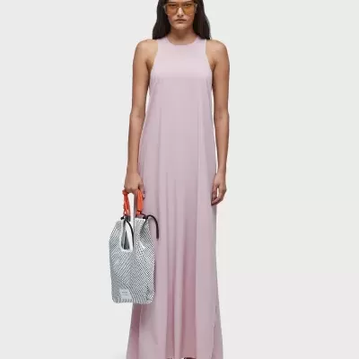 Mulher vestindo vestido longo rosa claro sem mangas e segurando bolsa branca com padrão em ziguezague preto e alças laranja
