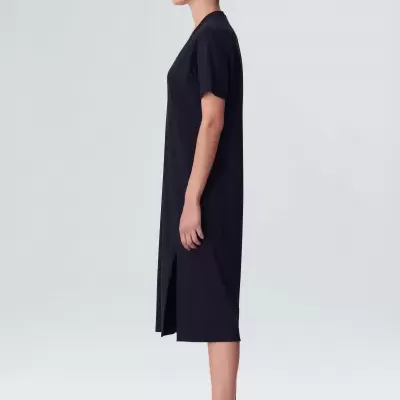 Vestido preto com fenda e ténis brancos com texto 'MADE IN BRAZIL'