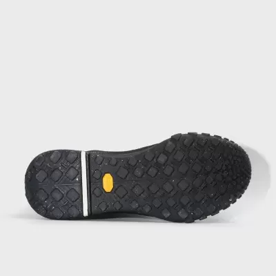 Sola preta de sapato com padrão texturizado e etiqueta amarela Vibram