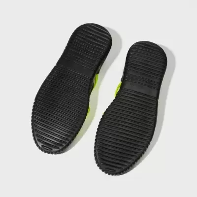 Solas de sapatos esportivos pretos com padrão de linhas horizontais sobre fundo branco