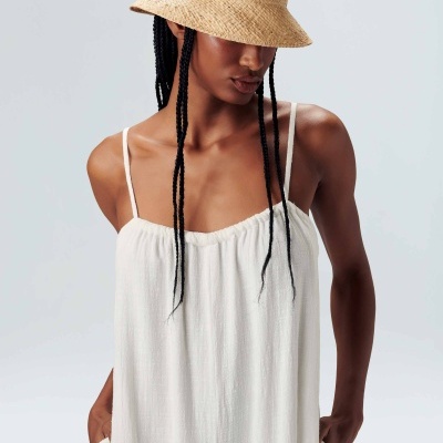 Vestido branco com alças finas e chapéu de palha natural
