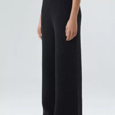 Calças pretas compridas em tecido texturizado com cintura alta