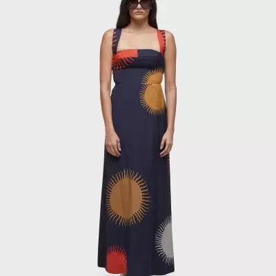 Vestido comprido com estampado circular em tecido escuro e óculos de sol