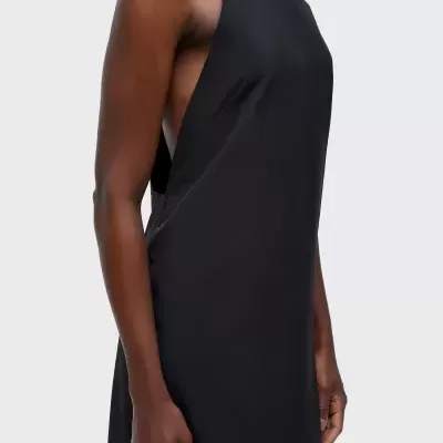 Mulher a usar vestido preto sem mangas com gola alta e lados cavados