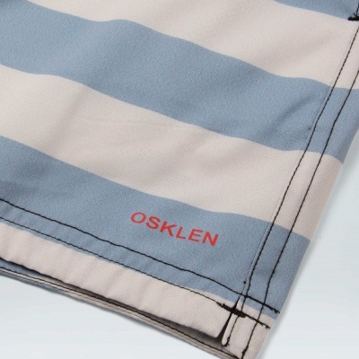 Tecido listrado azul claro e branco com logo OSKLEN vermelho e costura preta