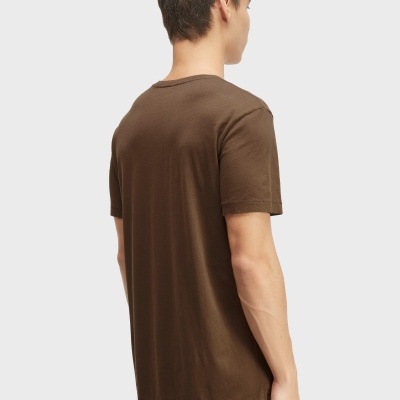 Homem de costas com t-shirt castanha e calças bege