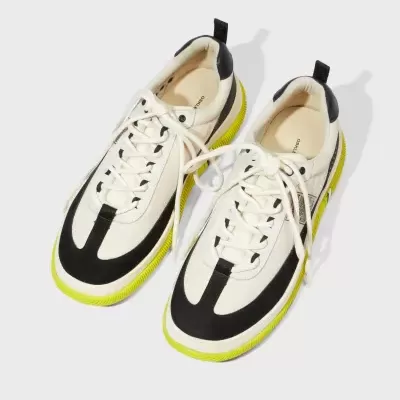 Sapatilhas creme e preto com sola amarela e atacadores brancos