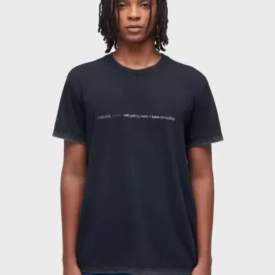 T-shirt preta com texto branco no peito usada por pessoa com calças de ganga azuis