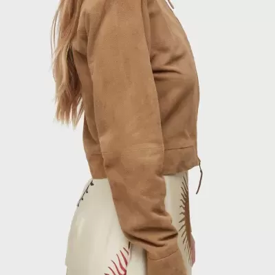 Casaco castanho curto de tecido aveludado usado por mulher em fundo cinza claro