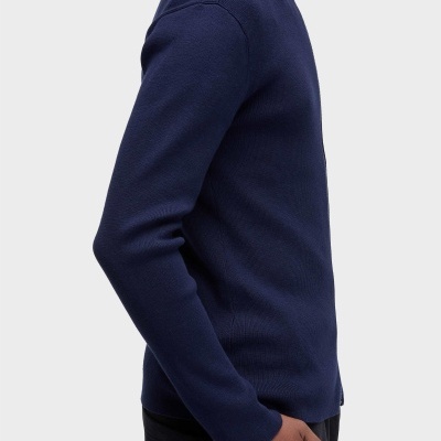 Camisola azul escuro de malha com fecho no colarinho usada por pessoa.