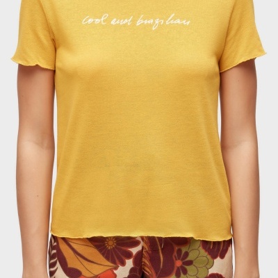 T-shirt amarela com texto branco e calções florais coloridos