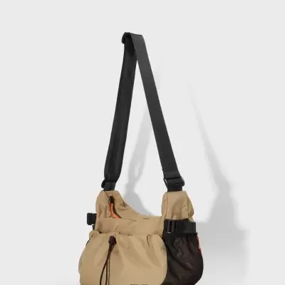 Bolsa bege com alça preta, bolsos em rede preta e texto OSKLEN