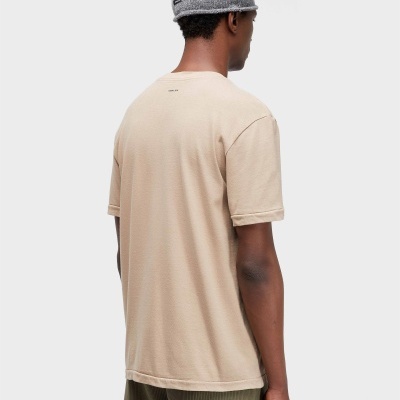 Homem de costas com t-shirt bege, calções verdes e gorro cinza