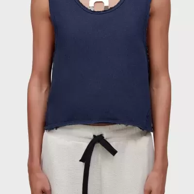 Top azul escuro sem mangas com bordas desfiadas e calças largas bege com cordão preto