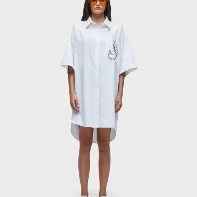 Vestido-camisa branco com padrão de cobra preto, óculos de sol laranja e calçado branco