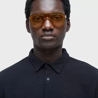 Homem com óculos de sol castanhos e camisa preta