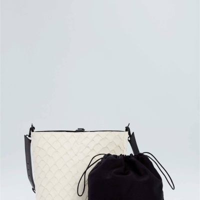 Duas bolsas, uma branca texturizada com alças pretas, e uma preta estilo saco com cordão.