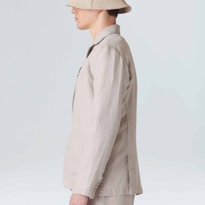 Pessoa de perfil com fato bege e chapéu de pescador bege