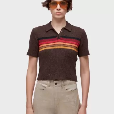 Mulher com t-shirt de malha castanha às riscas e óculos de sol castanhos