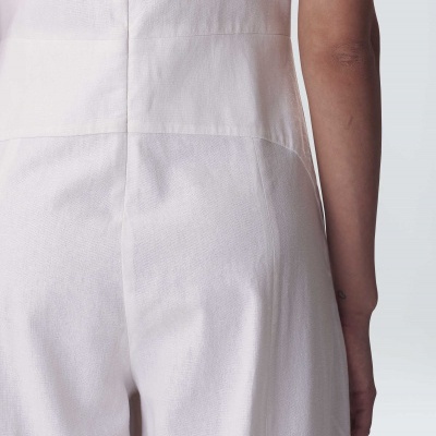 Macacão branco ou creme visto por trás, tecido liso e texturizado