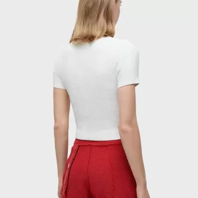 Pessoa vista de costas a usar top branco de manga curta e calças vermelhas largas