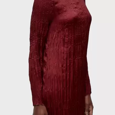 Vestido vermelho comprido com textura e mangas compridas num fundo claro