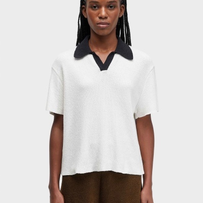 Top branco de malha com gola polo preta e calças castanhas