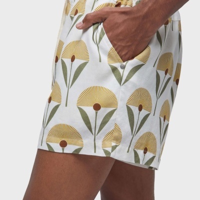 Calções curtos brancos com padrão floral amarelo e verde e bolso lateral