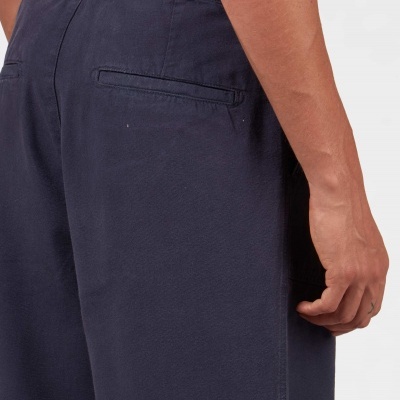 Calças azuis escuras com bolso traseiro usadas por pessoa, fundo branco