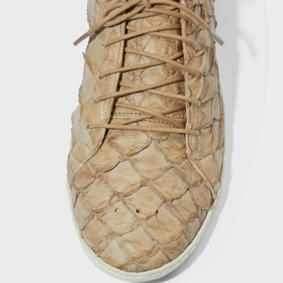 Sapato tipo ténis bege com padrão de escamas e sola branca