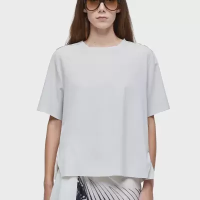 Mulher vestindo t-shirt branca e saia padrão preto e branco com óculos de sol