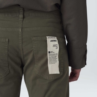 Calças de brim verde com etiqueta branca no bolso traseiro