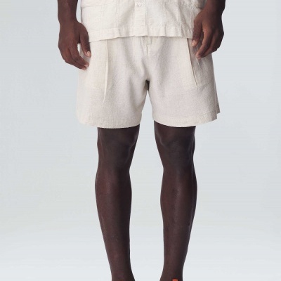 Calções bege claro com bolsos laterais usados por modelo