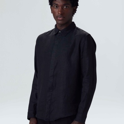 Homem com camisa preta de manga comprida e gola clássica em fundo branco