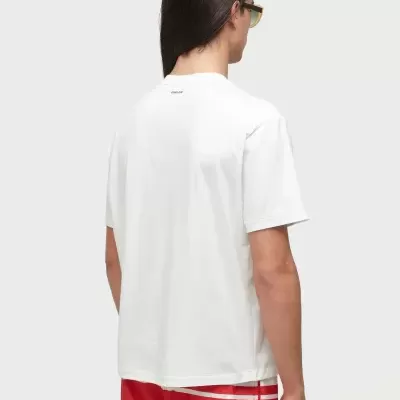 Homem de costas com t-shirt branca e calções vermelhos OSKLEN